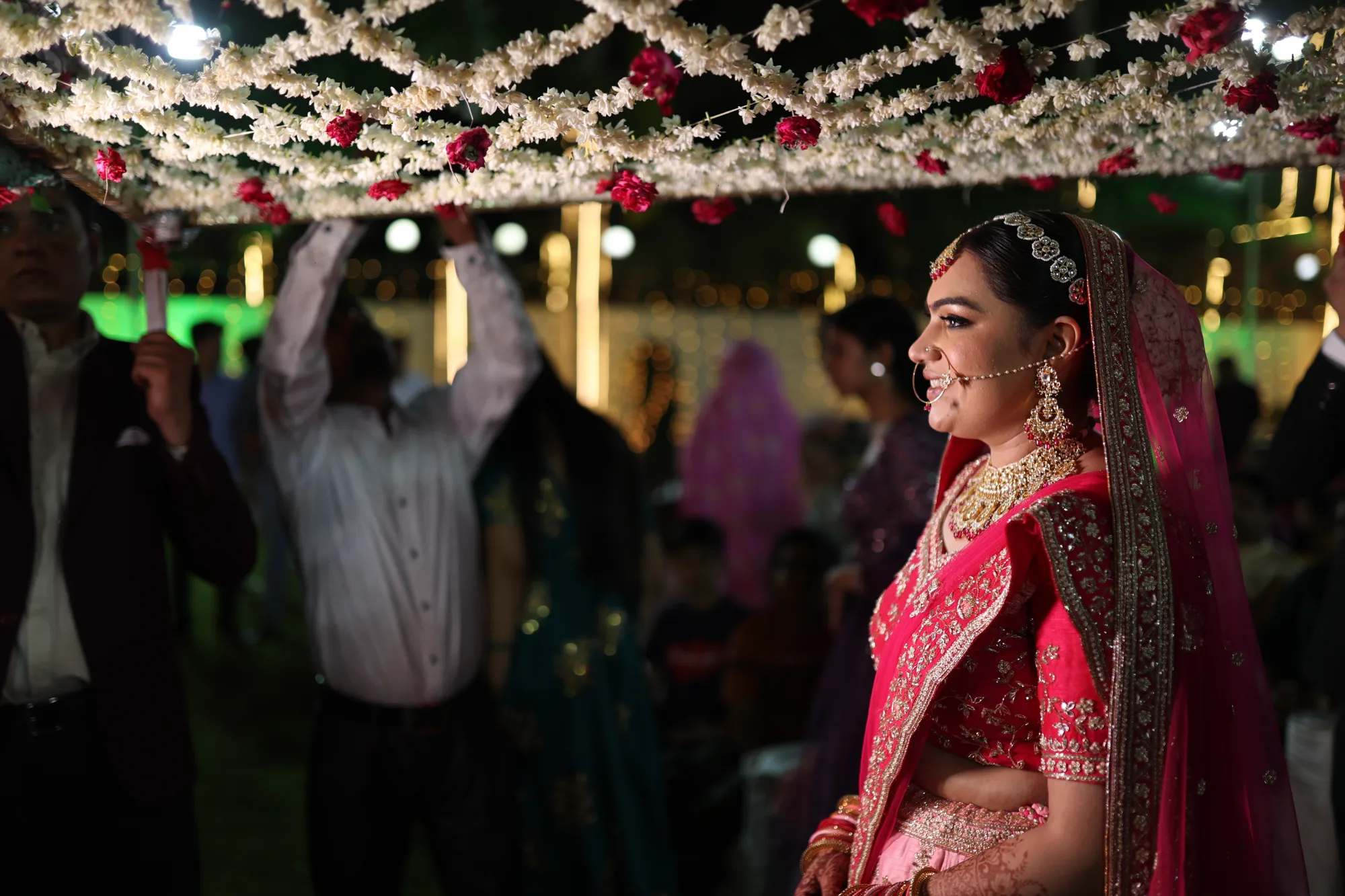 Woman in a pink lehenga at a brightly lit wedding venue
